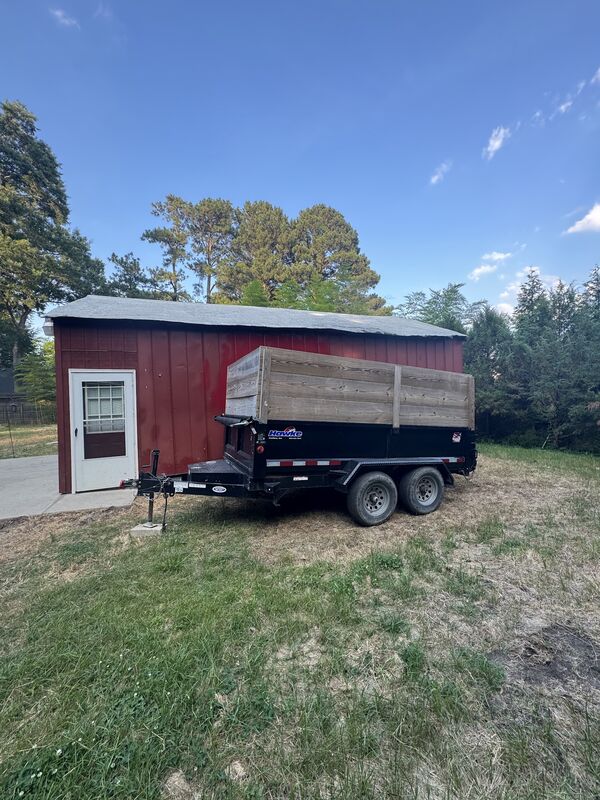 Dump trailer with high wood sides under a blue sky