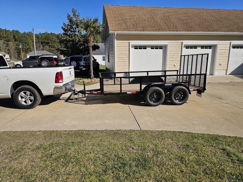 Thomas Enterprises truck with a utility trailer in a driveway