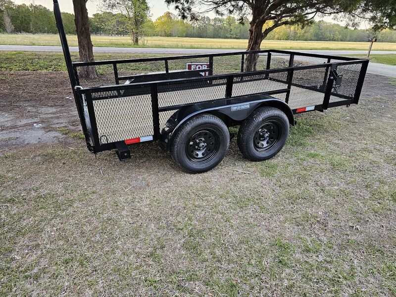 Utility trailer with ramp gate on a sunny lot